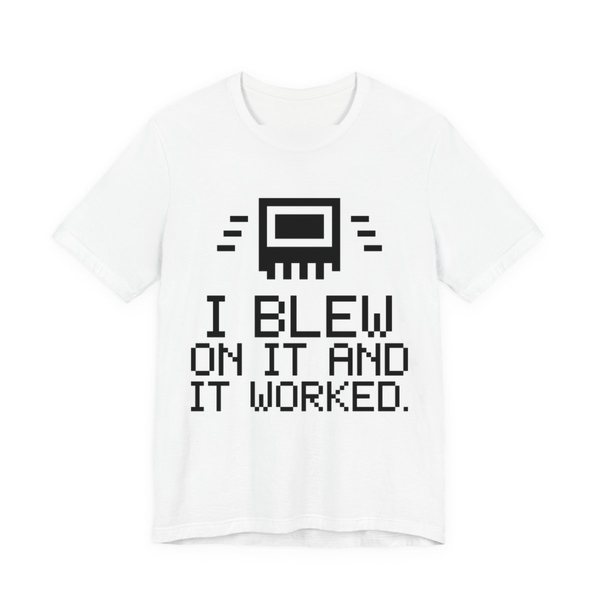 White t-shirt printed in dark ink with a pixel-art cartridge and the words “I Blew on It and It Worked.” in a blocky pixel font