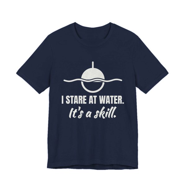 Navy t-shirt printed in off-white ink with a bobber on wavy water and the words “I Stare at Water. It's a Skill.”