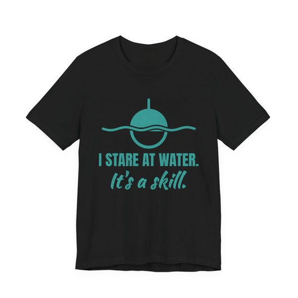 Black t-shirt printed in teal ink with a bobber on wavy water and the words “I Stare at Water. It's a Skill.”