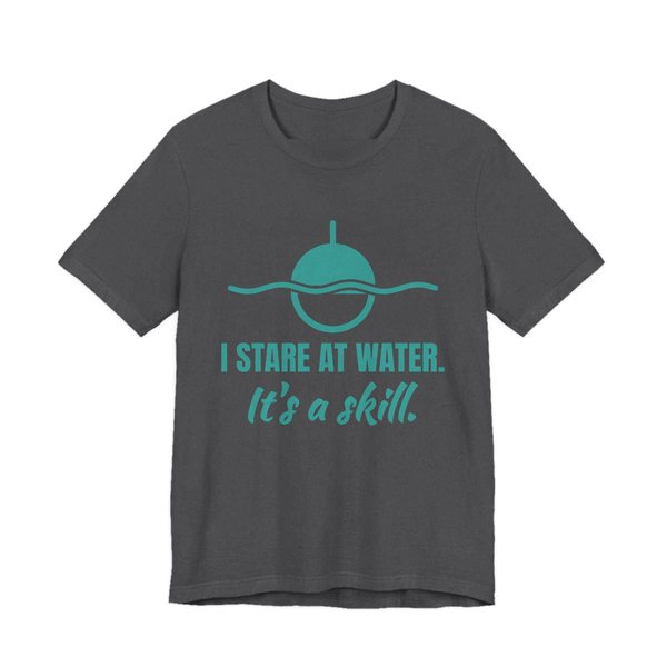 Dark Grey Heather t-shirt printed in teal ink with a bobber on wavy water and the words “I Stare at Water. It's a Skill.”
