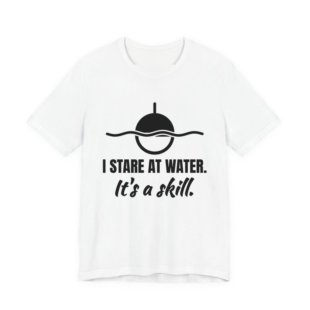 White t-shirt printed in dark ink with a bobber on wavy water and the words “I Stare at Water. It's a Skill.”