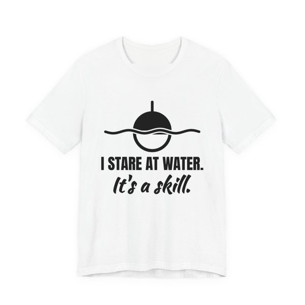 White t-shirt printed in dark ink with a bobber on wavy water and the words “I Stare at Water. It's a Skill.”