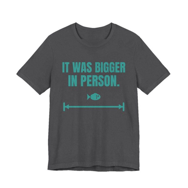 Dark Grey Heather t-shirt printed in teal ink with a small fish on a long measuring arrow and the words “It Was Bigger in Person.”