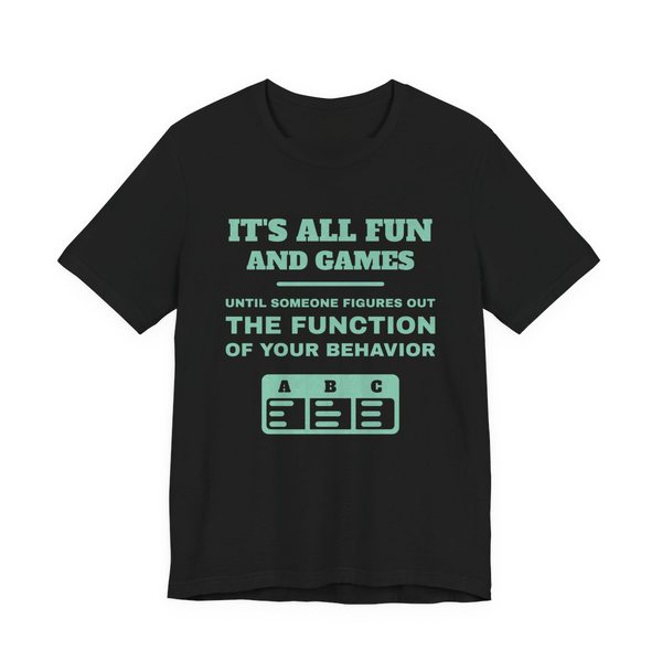 Black t-shirt printed in chalk mint ink with an ABC data chart and the words “It's all fun and games until someone figures out the function of your behavior”