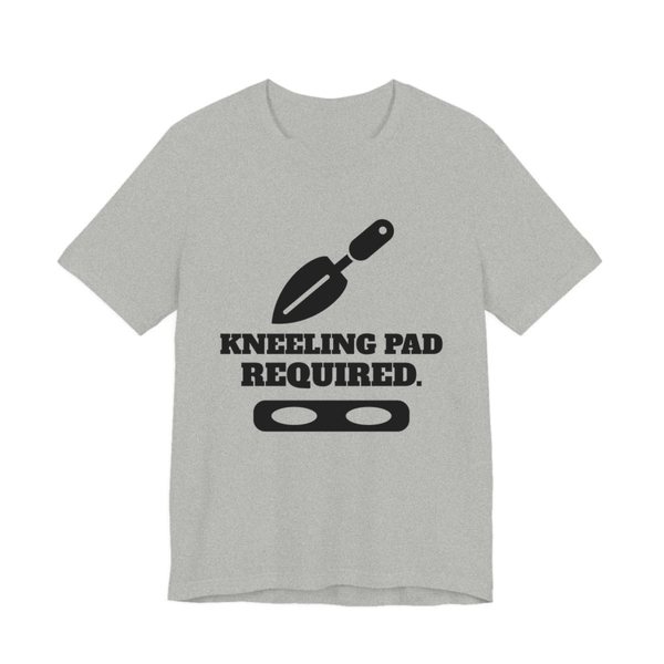 Athletic Heather t-shirt printed in dark ink with a trowel, a kneeling pad and the words “Kneeling Pad Required.”