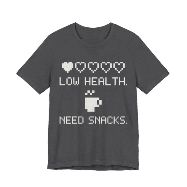 Dark Grey Heather t-shirt printed in off-white ink with a row of pixel hearts, a pixel mug and the words “Low Health. Need Snacks.”