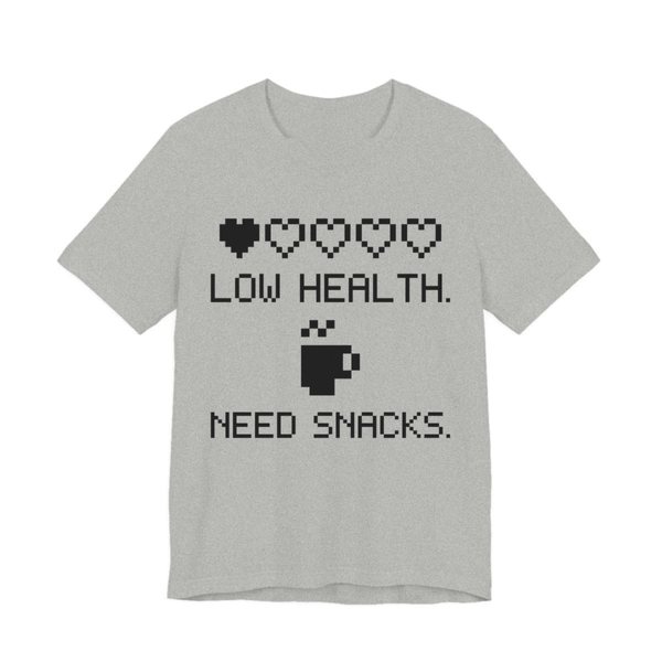Athletic Heather t-shirt printed in dark ink with a row of pixel hearts, a pixel mug and the words “Low Health. Need Snacks.”