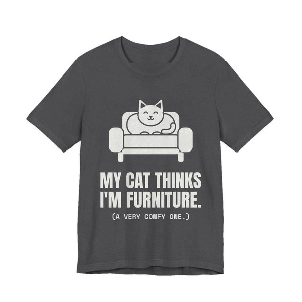 Dark Grey Heather t-shirt printed in off-white ink with a cat on an armchair and the words “My Cat Thinks I'm Furniture.”