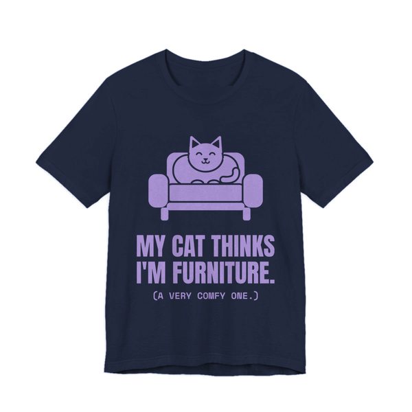 Navy t-shirt printed in lavender ink with a cat on an armchair and the words “My Cat Thinks I'm Furniture.”
