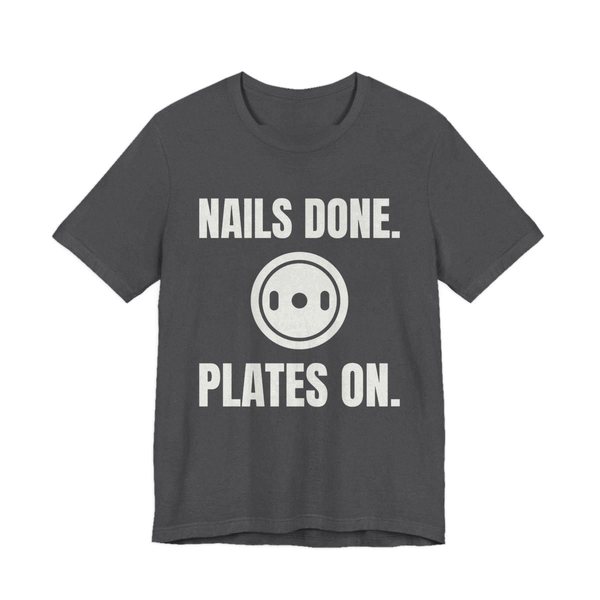 Dark Grey Heather t-shirt printed in off-white ink with a weight plate between the words "Nails Done." and "Plates On."