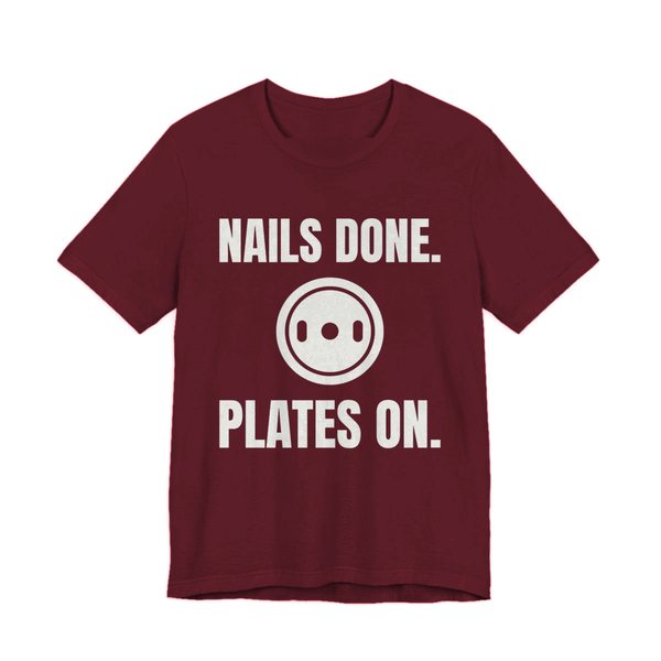 Maroon t-shirt printed in off-white ink with a weight plate between the words "Nails Done." and "Plates On."