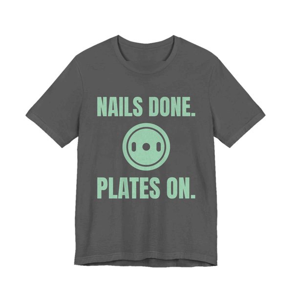 Asphalt t-shirt printed in mint green ink with a weight plate between the words "Nails Done." and "Plates On."