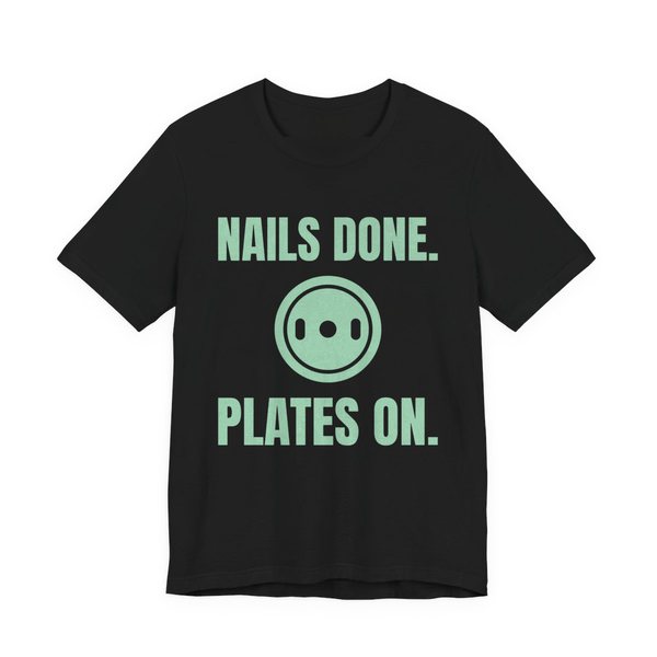 Black t-shirt printed in mint green ink with a weight plate between the words "Nails Done." and "Plates On."