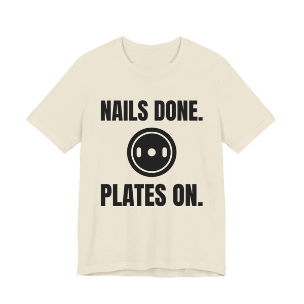 Natural t-shirt printed in dark ink with a weight plate between the words "Nails Done." and "Plates On."