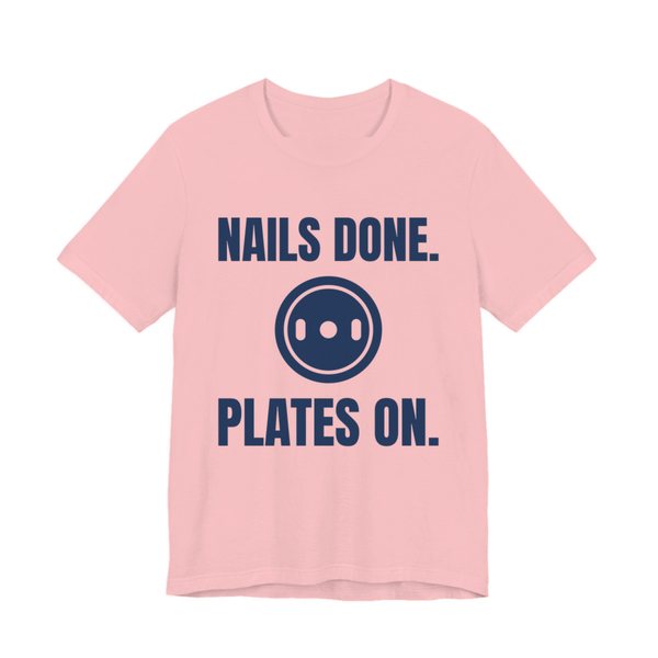 Pink t-shirt printed in navy blue ink with a weight plate between the words "Nails Done." and "Plates On."