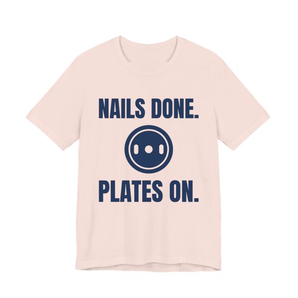 Soft Pink t-shirt printed in navy blue ink with a weight plate between the words "Nails Done." and "Plates On."