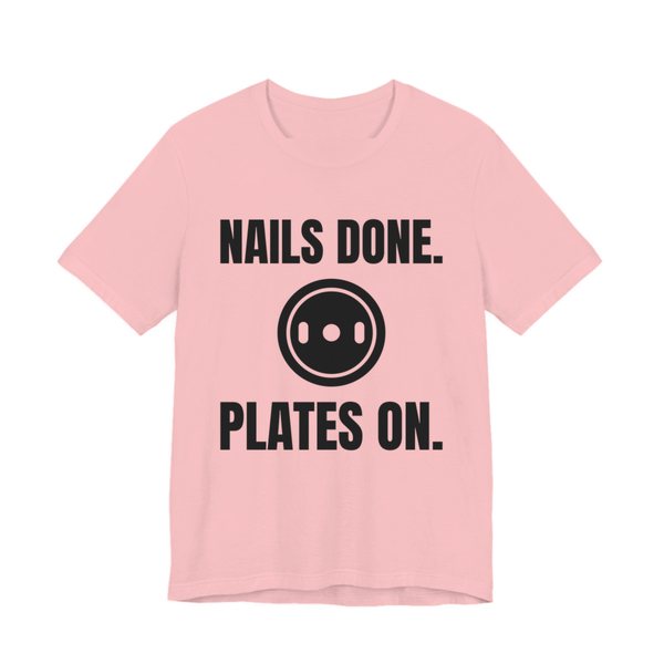 Pink t-shirt printed in dark ink with a weight plate between the words "Nails Done." and "Plates On."