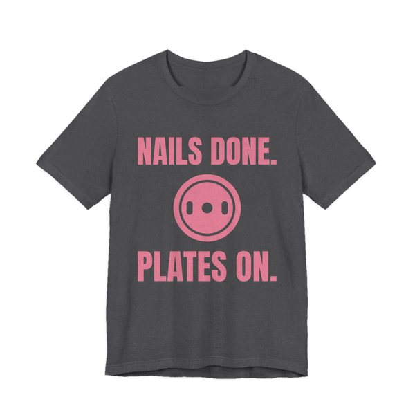 Dark Grey Heather t-shirt printed in rose pink ink with a weight plate between the words "Nails Done." and "Plates On."