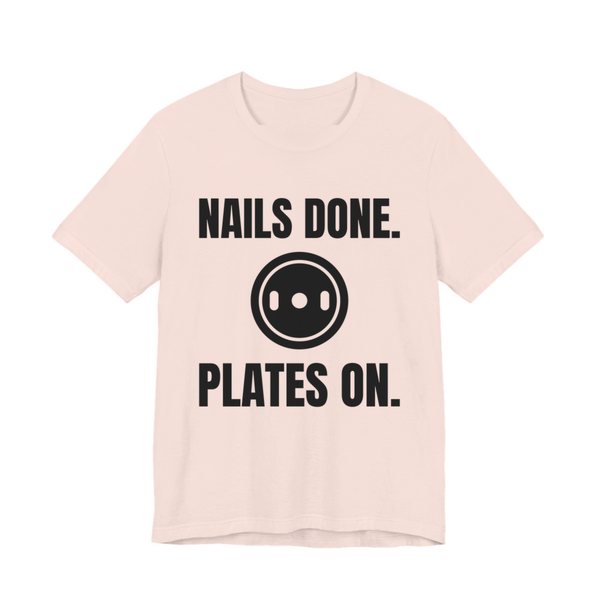 Soft Pink t-shirt printed in dark ink with a weight plate between the words "Nails Done." and "Plates On."