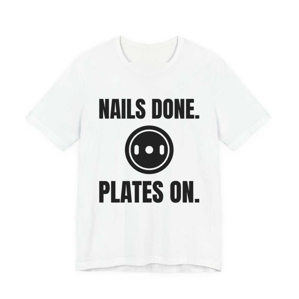 White t-shirt printed in dark ink with a weight plate between the words "Nails Done." and "Plates On."