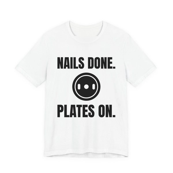 White t-shirt printed in dark ink with a weight plate between the words "Nails Done." and "Plates On."