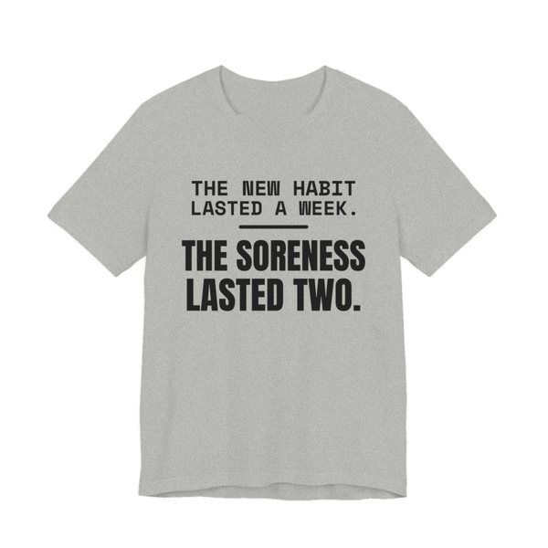 Athletic Heather t-shirt printed in dark ink with the words “New Habit Lasted a Week. The Soreness Lasted Two.”