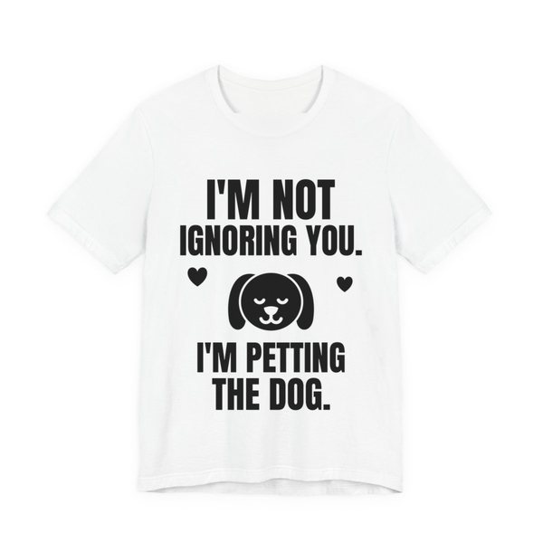 White t-shirt printed in dark ink with a content dog face with hearts and the words “I'm Not Ignoring You. I'm Petting the Dog.”