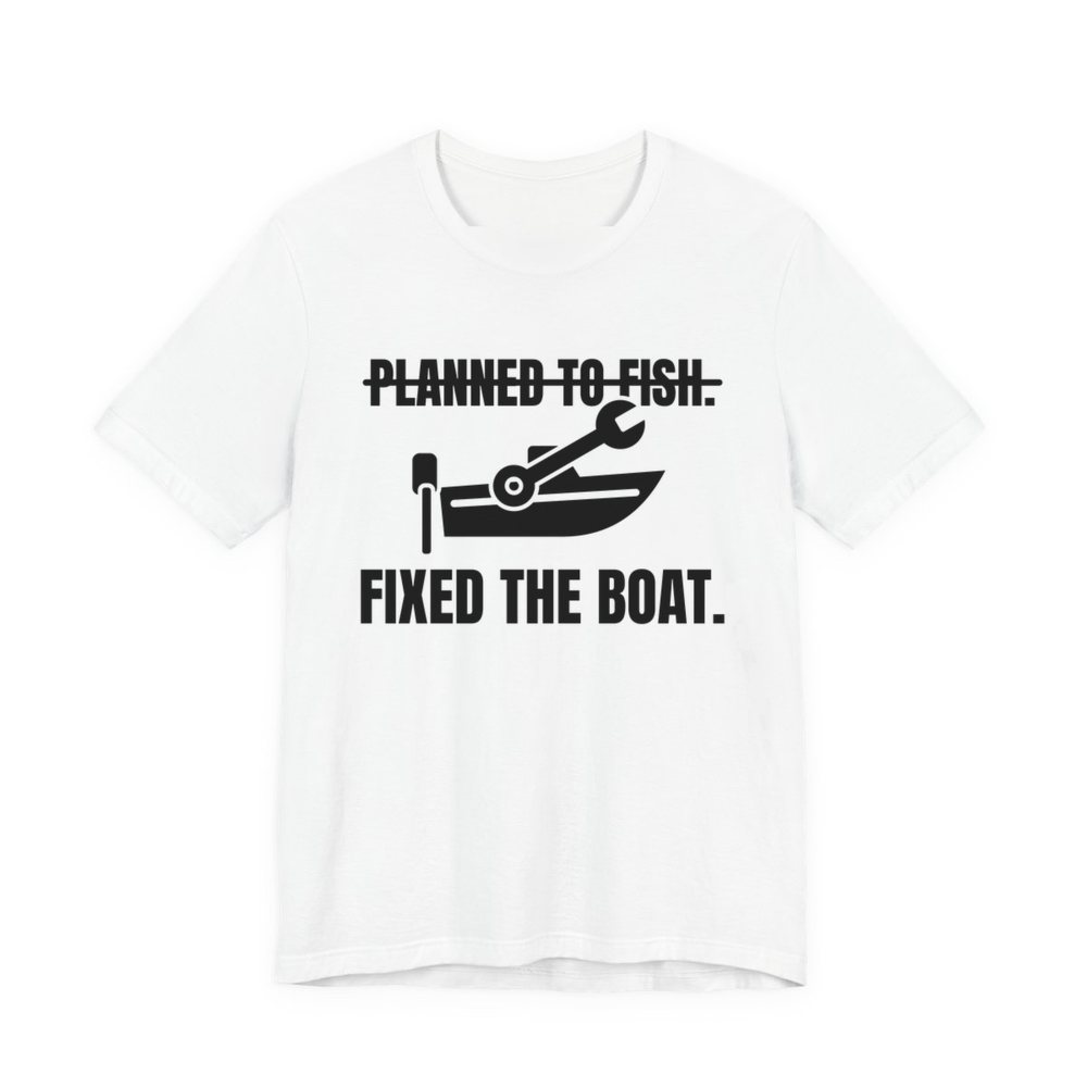 White t-shirt printed in dark ink with a boat and a wrench, with “Planned to Fish.” crossed out above “Fixed the Boat.”