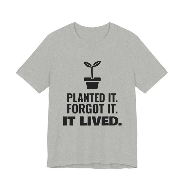 Athletic Heather t-shirt printed in dark ink with a sprout in a flowerpot and the words “Planted It. Forgot It. It Lived.”