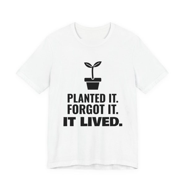 White t-shirt printed in dark ink with a sprout in a flowerpot and the words “Planted It. Forgot It. It Lived.”