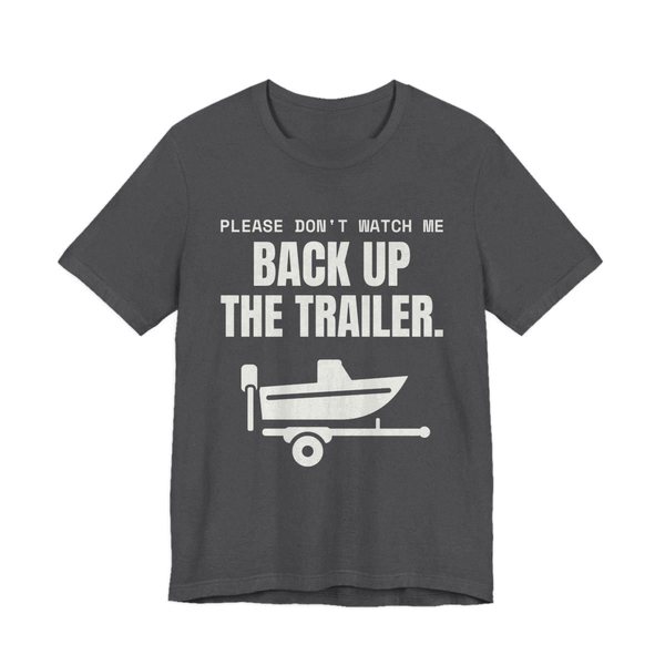 Dark Grey Heather t-shirt printed in off-white ink with a boat on a trailer and the words “Please Don't Watch Me Back Up the Trailer.”