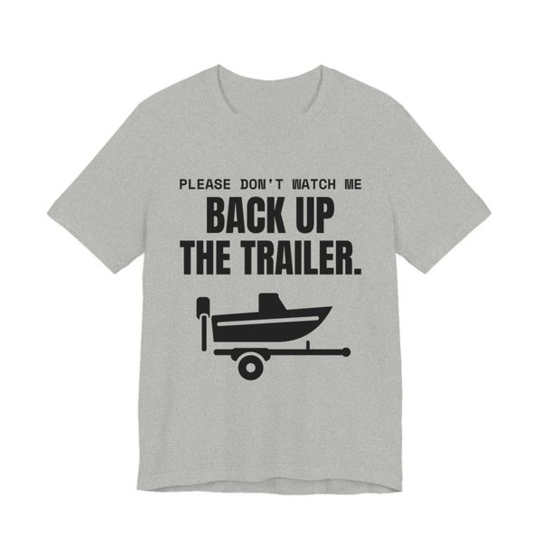 Athletic Heather t-shirt printed in dark ink with a boat on a trailer and the words “Please Don't Watch Me Back Up the Trailer.”