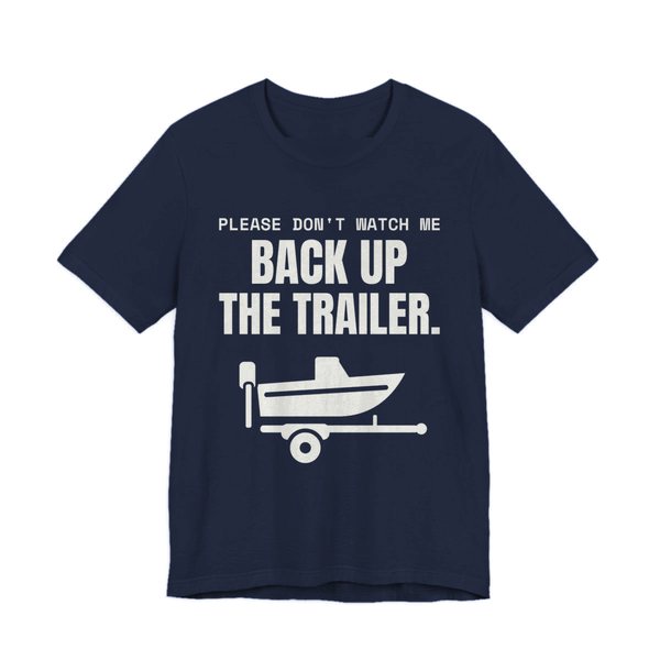 Navy t-shirt printed in off-white ink with a boat on a trailer and the words “Please Don't Watch Me Back Up the Trailer.”