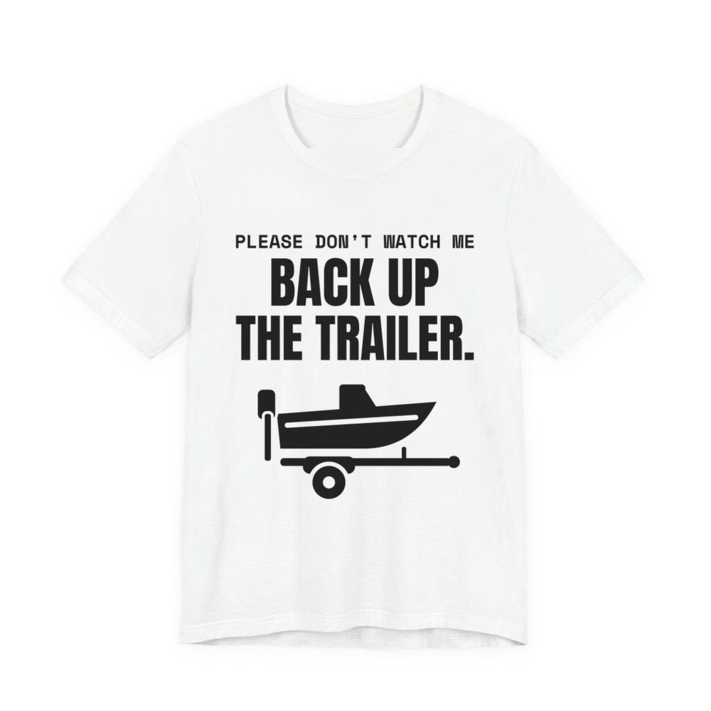White t-shirt printed in dark ink with a boat on a trailer and the words “Please Don't Watch Me Back Up the Trailer.”