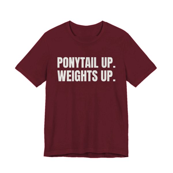 Maroon t-shirt printed in off-white ink with the words "Ponytail Up. Weights Up."