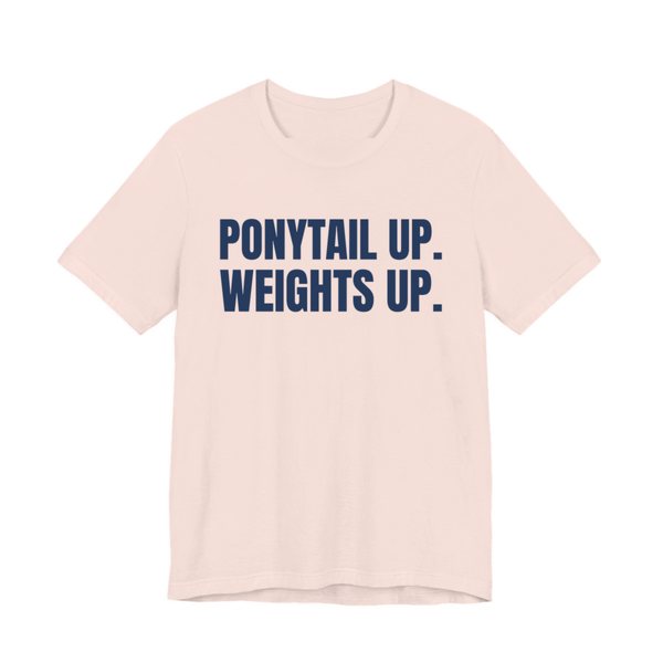 Soft Pink t-shirt printed in navy blue ink with the words "Ponytail Up. Weights Up."
