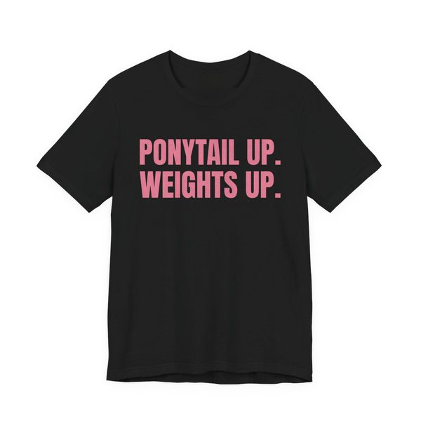 Black t-shirt printed in rose pink ink with the words "Ponytail Up. Weights Up."