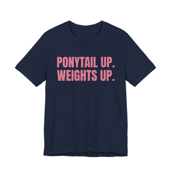 Navy t-shirt printed in rose pink ink with the words "Ponytail Up. Weights Up."