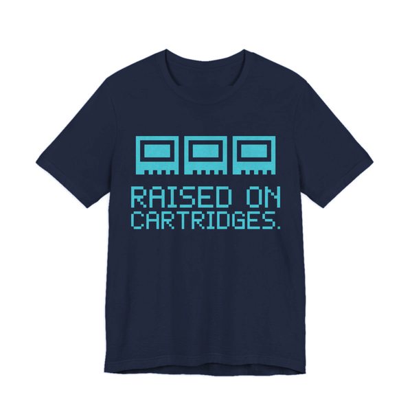 Navy t-shirt printed in cyan ink with three plain pixel cartridges and the words “Raised on Cartridges.”