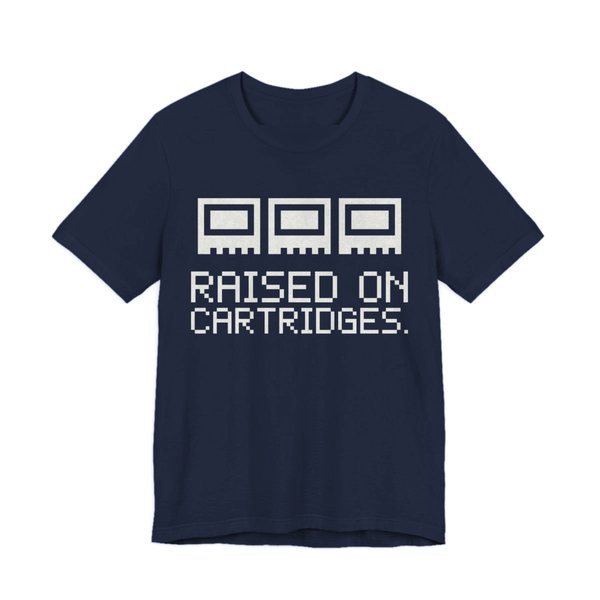 Navy t-shirt printed in off-white ink with three plain pixel cartridges and the words “Raised on Cartridges.”