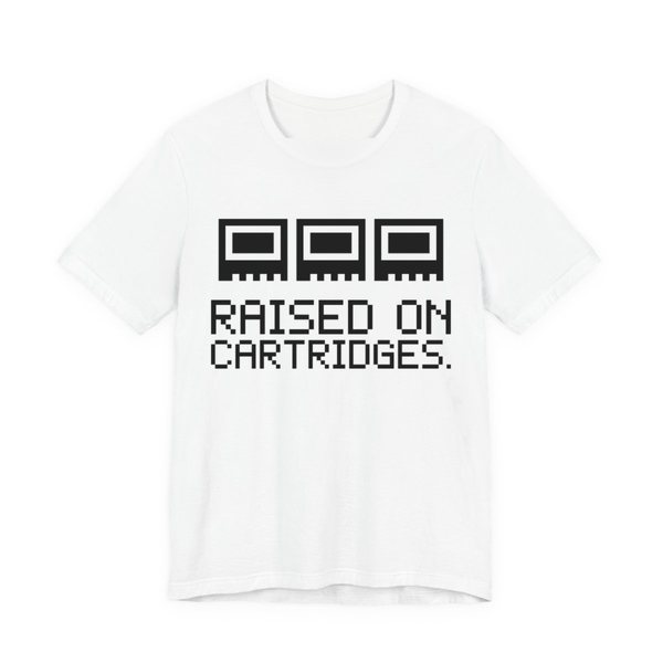 White t-shirt printed in dark ink with three plain pixel cartridges and the words “Raised on Cartridges.”