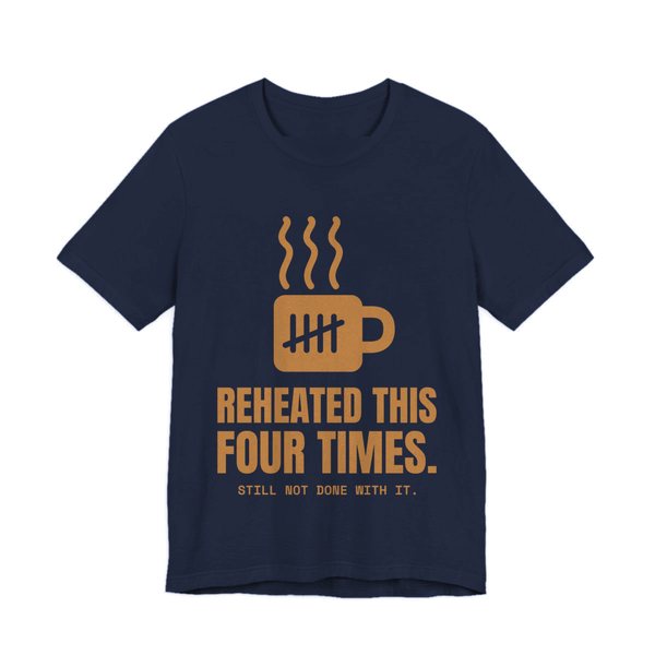 Navy t-shirt printed in caramel ink with a mug with tally marks and the words “Reheated This Four Times.”