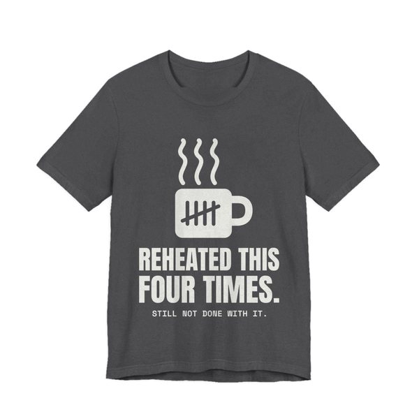 Dark Grey Heather t-shirt printed in off-white ink with a mug with tally marks and the words “Reheated This Four Times.”