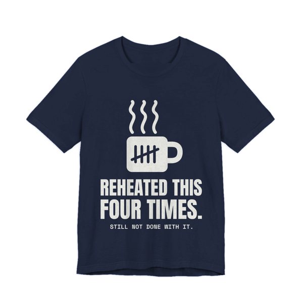 Navy t-shirt printed in off-white ink with a mug with tally marks and the words “Reheated This Four Times.”