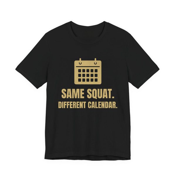 Black t-shirt printed in champagne gold ink with a wall calendar and the words “Same Squat. Different Calendar.”