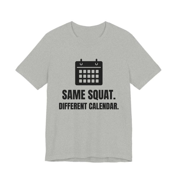 Athletic Heather t-shirt printed in dark ink with a wall calendar and the words “Same Squat. Different Calendar.”