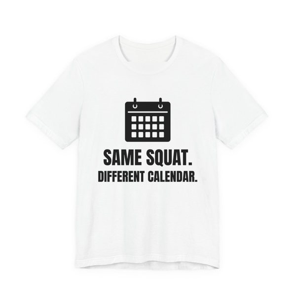 White t-shirt printed in dark ink with a wall calendar and the words “Same Squat. Different Calendar.”