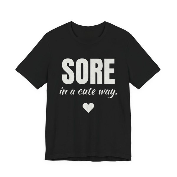 Black t-shirt printed in off-white ink with a heart and the words "Sore in a Cute Way."