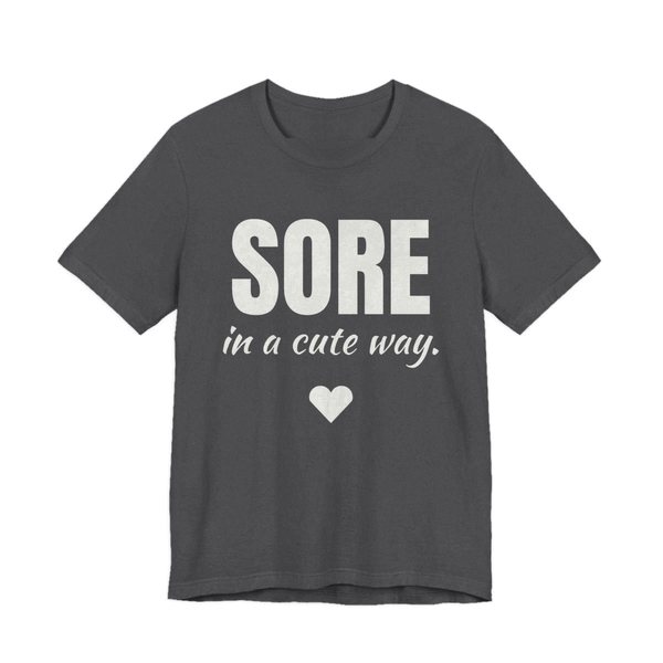 Dark Grey Heather t-shirt printed in off-white ink with a heart and the words "Sore in a Cute Way."
