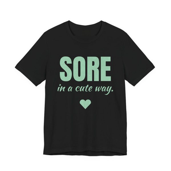 Black t-shirt printed in mint green ink with a heart and the words "Sore in a Cute Way."
